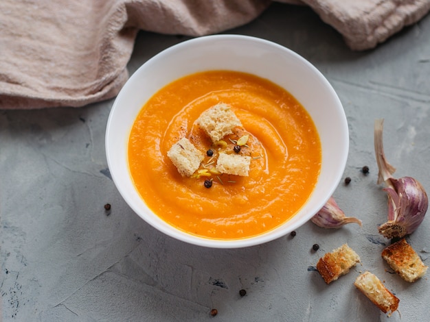 Sopa de abóbora picante com pão torrado e sementes de abóbora.