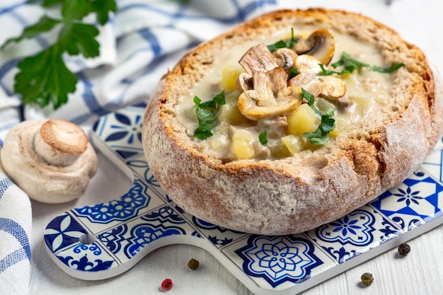 Sopa de batata caseira com cogumelos em um pão servido com salsa fresca
