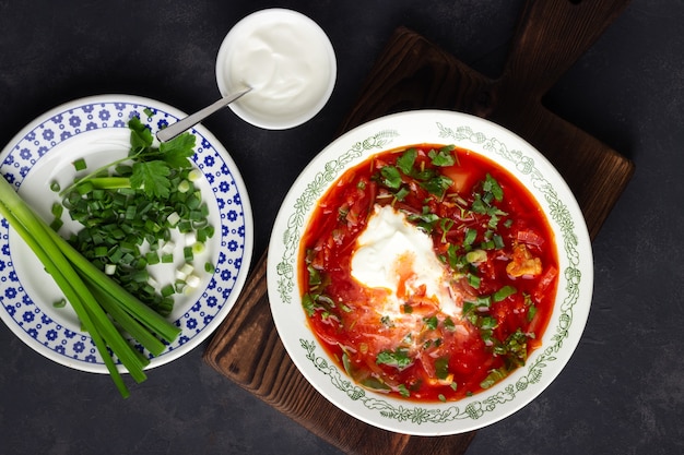 Sopa de beterraba ucraniana - borscht com creme de leite no fundo de pedra preta. Vista do topo.