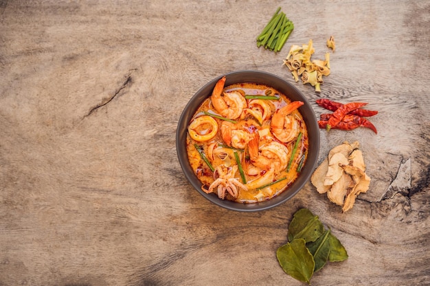 Sopa de camarão e capim-limão com comida tailandesa de yam kung cogumelos em vista superior de fundo de madeira