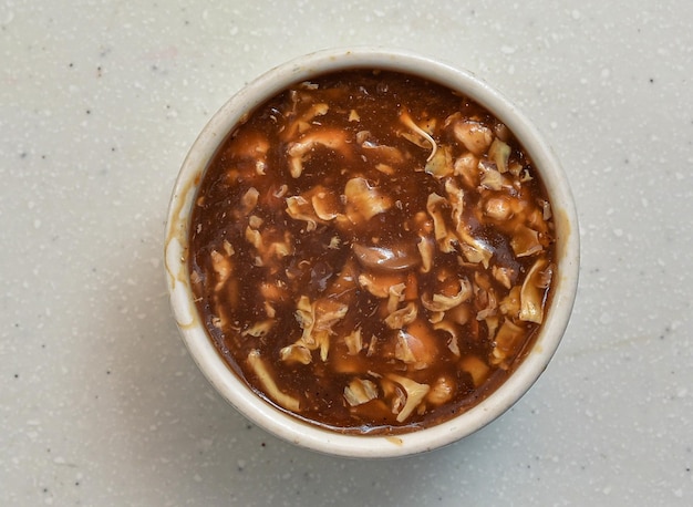 Sopa de carne quente servida em uma tigela isolada na vista superior de fundo cinza da comida indiana paquistanesa