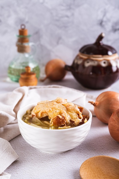 Sopa de cebola caseira com croutons e queijo em uma tigela na mesa, vista vertical