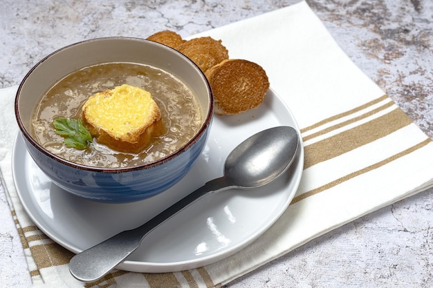 Sopa de cebola francesa caseira tradicional com pão gratinado na mesa de mármore bowlon. conceito de comida saudável.