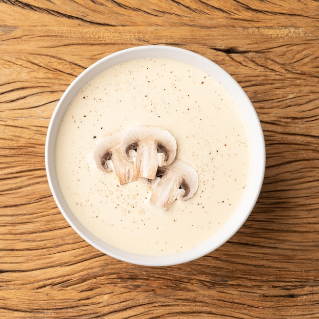 Sopa de cogumelos em uma tigela sobre a mesa de madeira