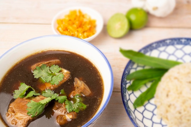 Sopa de costelinha de porco picante caseira servida com arroz integral na mesa de madeira