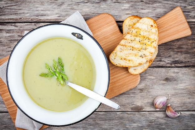 Sopa de creme caseira com aspargos e ciabatta torrado em fundo rústico