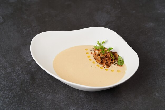 Sopa de creme com peixe dourada em fundo cinza com espaço de cópia, close-up