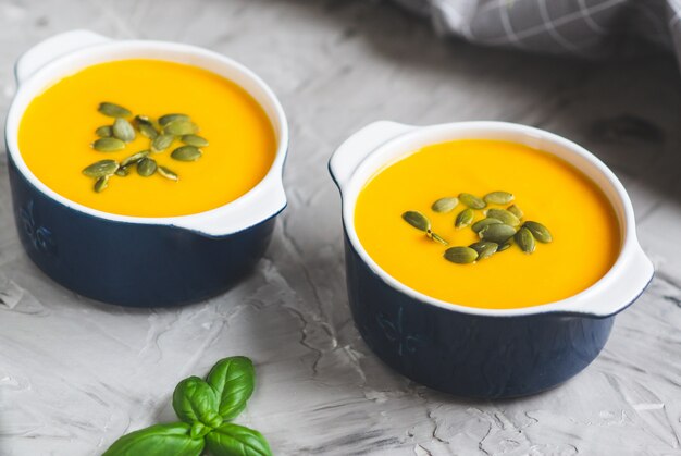 Sopa de creme de abóbora com sementes Outono saudável vegetariana comida cinza de fundo