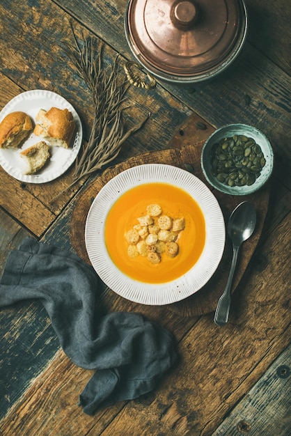 Sopa de creme de abóbora de aquecimento com croutons e composição vertical de sementes