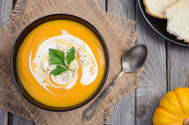 Sopa de creme de abóbora na mesa de madeira rústica