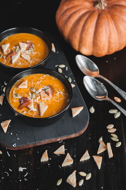 Sopa de creme de abóbora. superfície escura. luz natural.