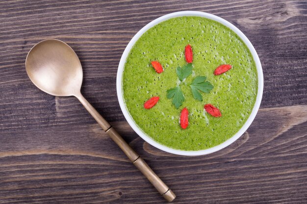 Sopa de creme verde de espinafre na mesa de madeira fechar