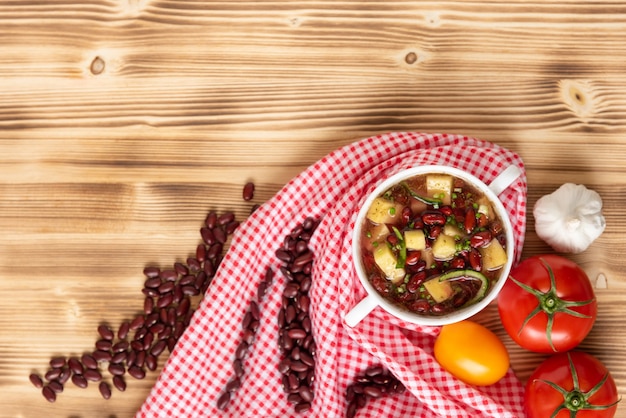 Sopa de feijão vermelho com batata, tomate e páprica em uma tigela de cerâmica. Vista do topo.