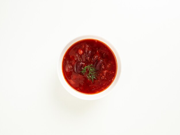 Sopa de feijão vermelho em uma tigela branca sobre uma mesa branca, borsch, vista de cima