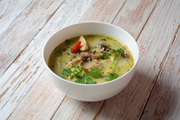 Sopa de frango com curry verde picante tailandês com leite de coco, cogumelos e brócolis.