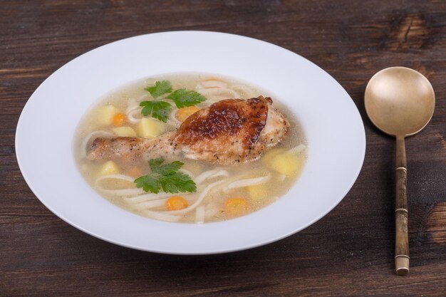 Sopa de frango com macarrão e legumes em chapa branca