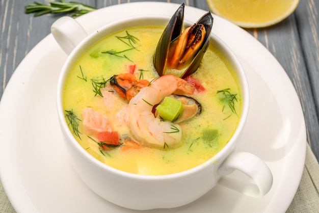 Foto sopa de frutos do mar, em uma mesa de madeira, com camarão