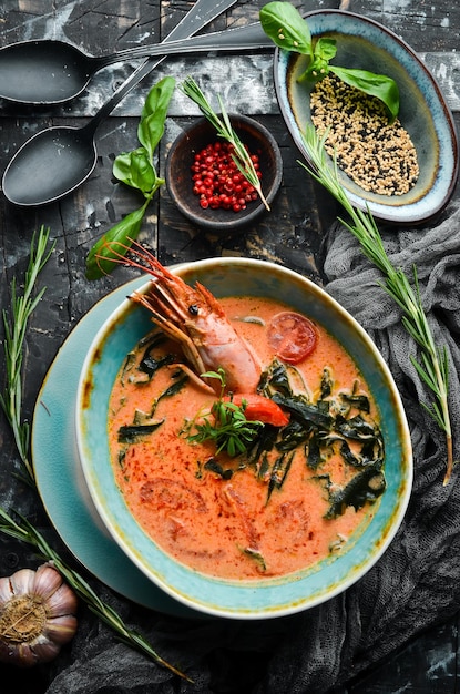 Sopa de frutos do mar Sopa de tomate com camarão em uma tigela sobre fundo de pedra preta Vista superior Estilo rústico