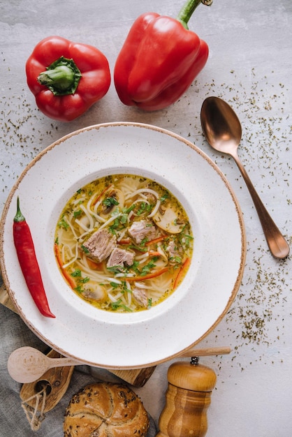 Sopa de galinha com macarrão e legumes em tigela branca