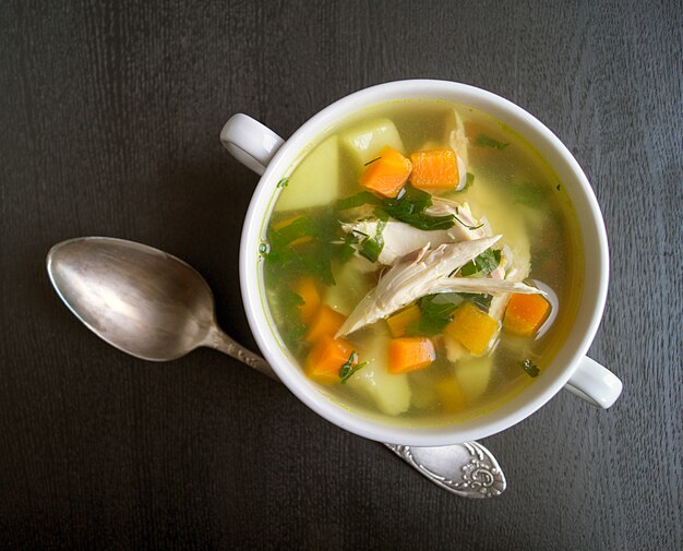 Foto sopa de galinha na tabela preta.