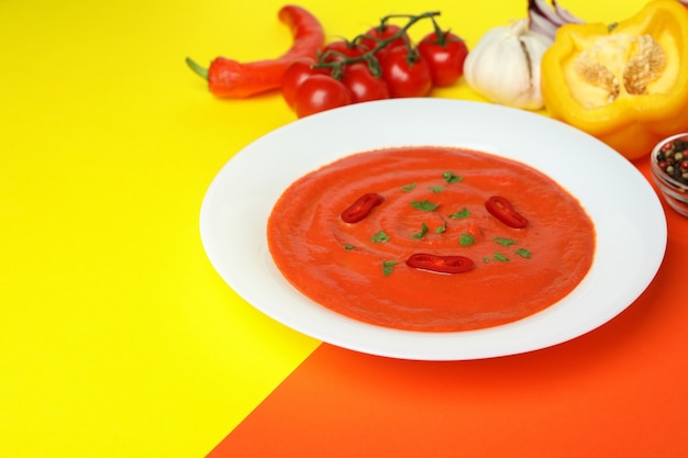 Sopa de gaspacho e ingredientes em fundo de dois tons