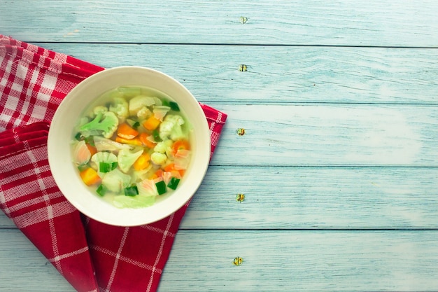 Sopa de legumes caseira vista de perto em um fundo de madeira velha