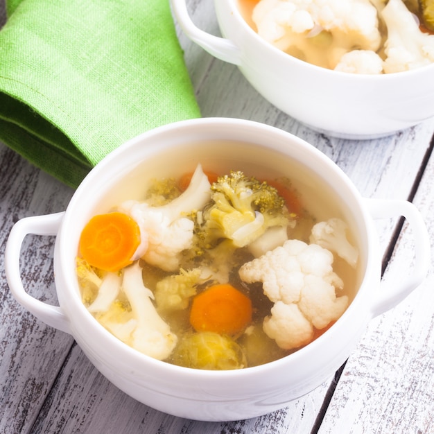 Sopa de legumes em tigela branca close-up em cima da mesa