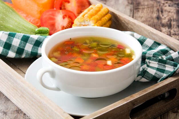 Sopa de legumes em tigela na mesa de madeira