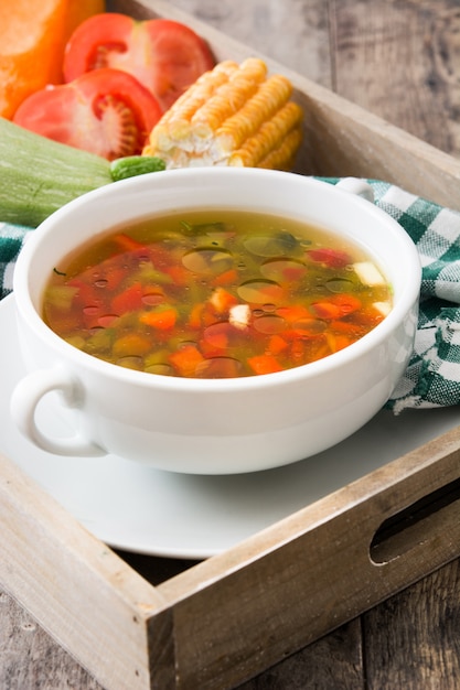 Foto sopa de legumes em tigela na mesa de madeira