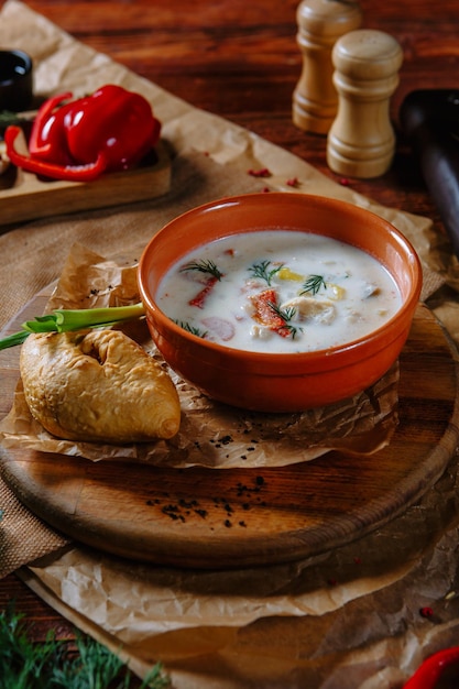 Sopa de legumes em uma panela de barro com creme de leite Vista superior