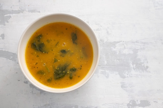 Sopa de legumes em uma tigela com fundo de cerâmica