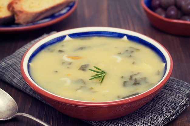 Sopa de legumes em uma tigela e azeitonas com pão de milho