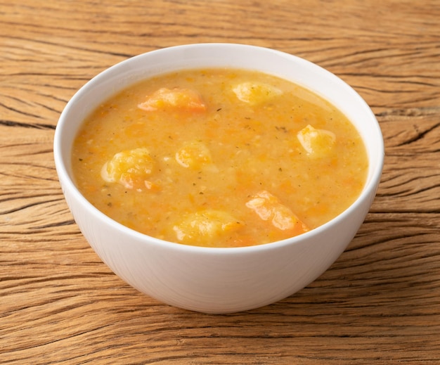 Sopa de legumes em uma tigela sobre a mesa de madeira