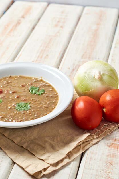 Sopa de lentilha com ingredientes ao lado prato caseiro saudável