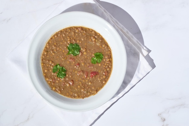 Sopa de lentilha com ingredientes ao lado prato caseiro saudável
