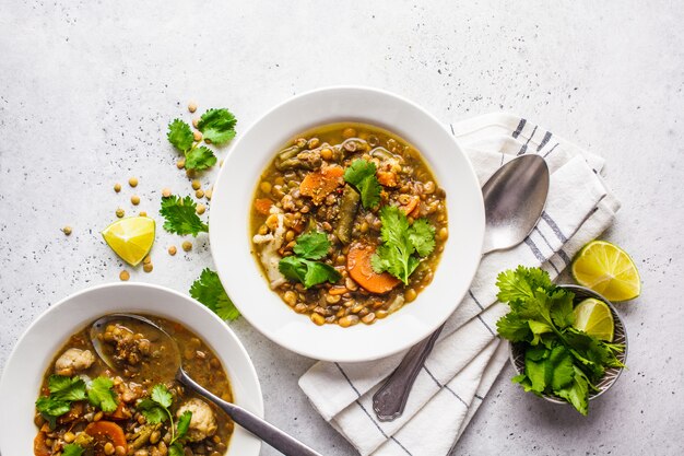 Sopa de lentilha com vegetais em uma placa branca, fundo branco, vista superior. Alimentos à base de plantas, comer limpo.