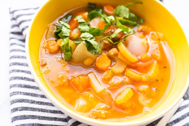 Sopa de lentilha fresca guarnecida com espinafre fresco em uma tigela.