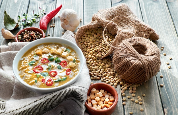 Sopa de lentilha picante com pimentão, alho e cebola na mesa de madeira rústica.