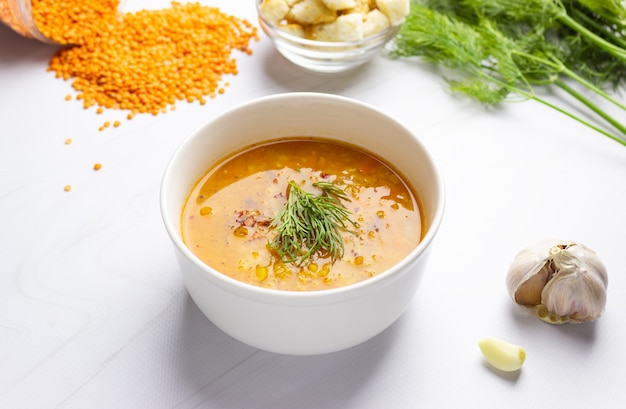 Sopa de lentilha vermelha com ingredientes em um fundo claro. Lentilha picante tradicional turca ou árabe e sopa de vegetais, comida vegana saudável. Vista lateral