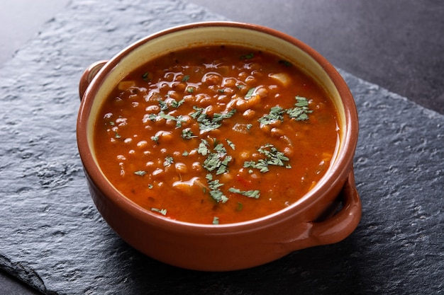 Sopa de lentilha vermelha em fundo de ardósia preta