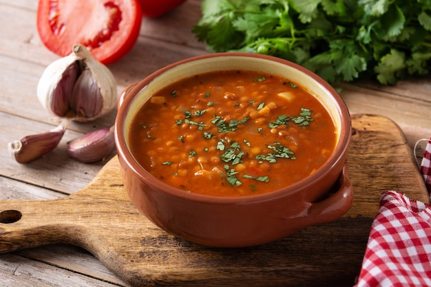 Sopa de lentilha vermelha em uma tigela na mesa de madeira