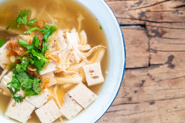 Foto sopa de macarrão de arroz vietnamita com carne de porco e frango na mesa de madeira