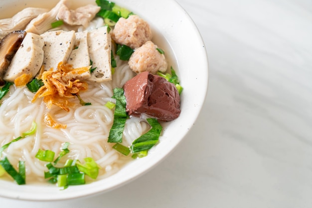 Sopa de macarrão de arroz vietnamita com linguiça vietnamita servida com legumes e cebola crocante