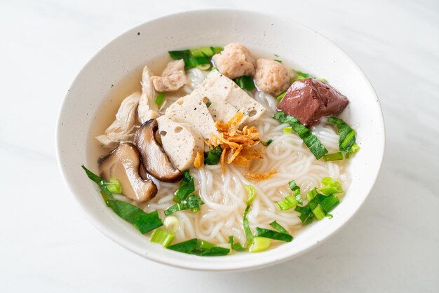 Sopa de macarrão de arroz vietnamita com linguiça vietnamita servida com legumes e cebola crocante