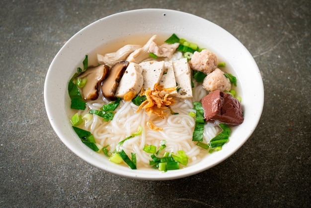 Sopa de macarrão de arroz vietnamita com linguiça vietnamita servida com legumes e cebola crocante