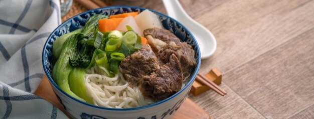 Sopa de macarrão de carne Close-up da famosa comida taiwanesa em uma tigela na mesa de madeira