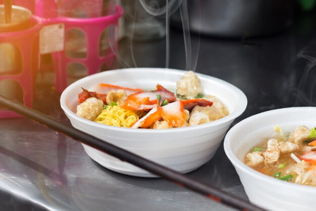Sopa de macarrão em uma espuma de arco de comida de rua é fast food turístico popular, tailândia