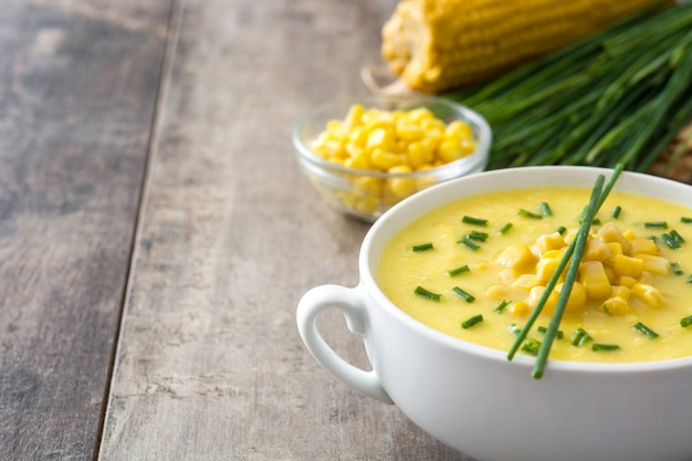 Sopa de milho em uma tigela no espaço da cópia de madeira