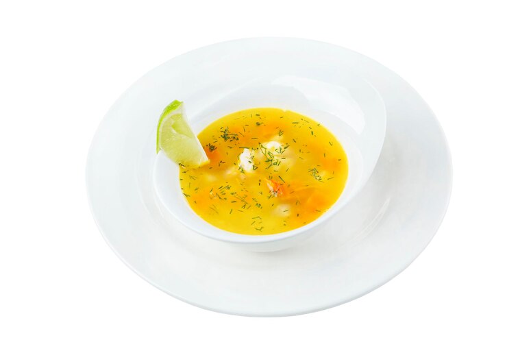 Foto sopa de peixe dourado com uma fatia de limão em uma tigela branca appetitnon é um prato tradicional isolado no fundo branco