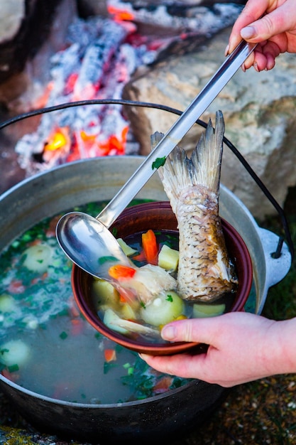 Sopa de peixe preparada em fogo aberto